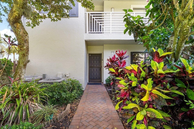 doorway to property featuring a balcony and stucco siding