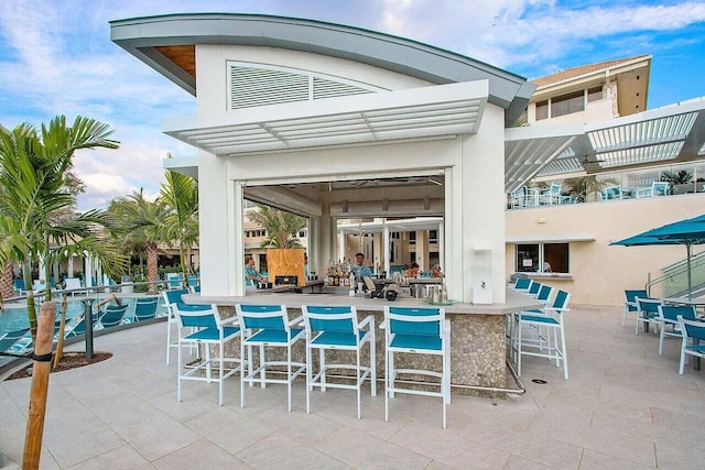 view of swimming pool with a patio and outdoor dry bar