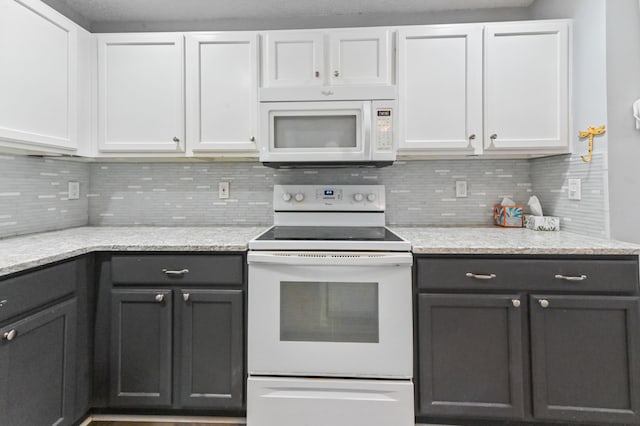 kitchen featuring white appliances, tasteful backsplash, and white cabinetry