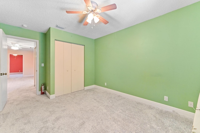 unfurnished bedroom with carpet, baseboards, visible vents, a closet, and a textured ceiling