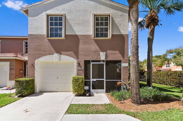 view of front facade with concrete driveway, a garage, and stucco siding