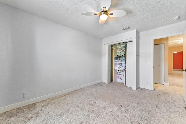 unfurnished bedroom featuring carpet, baseboards, visible vents, a closet, and a textured ceiling