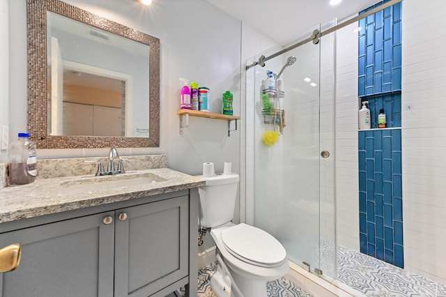 bathroom with a shower stall, toilet, and vanity