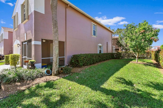 view of property exterior with stucco siding and a yard