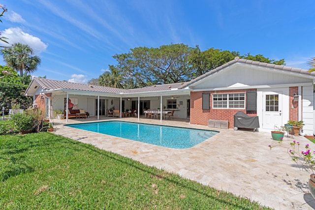 pool featuring outdoor lounge area, a lawn, and a patio area