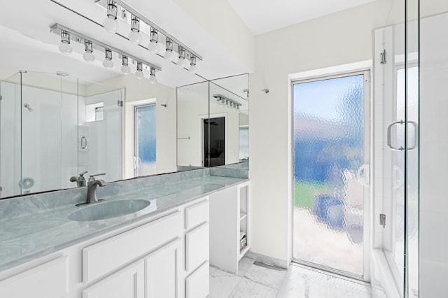 bathroom with marble finish floor, a shower stall, and vanity