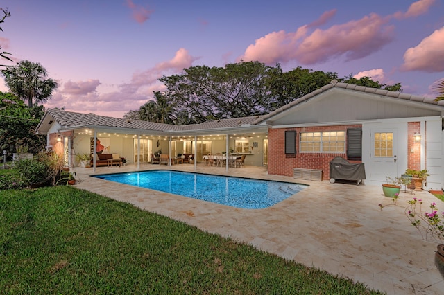 pool featuring a yard, an outdoor living space, and a patio