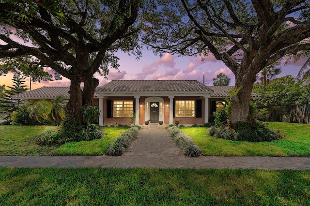 view of front of home featuring a front yard and a tile roof