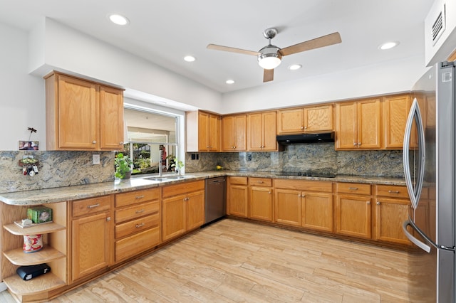 kitchen featuring under cabinet range hood, stainless steel appliances, a sink, light wood-style floors, and light stone countertops