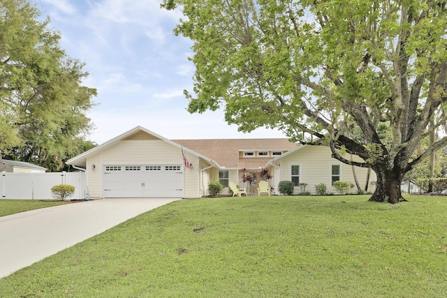 single story home featuring an attached garage, fence, a front lawn, and concrete driveway