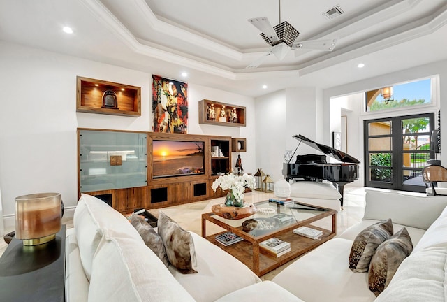 living area with a tray ceiling, crown molding, french doors, and visible vents