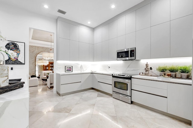 kitchen featuring modern cabinets, visible vents, appliances with stainless steel finishes, and arched walkways