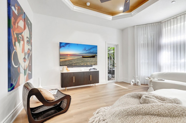 living room with baseboards, a raised ceiling, ceiling fan, and wood finished floors