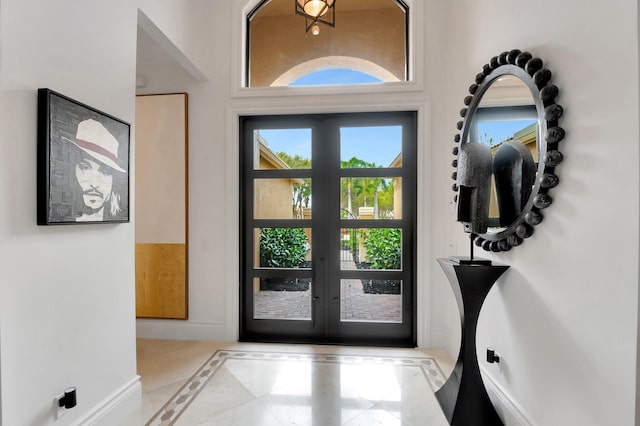 doorway with french doors and baseboards