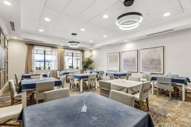 dining space with recessed lighting, visible vents, and a raised ceiling