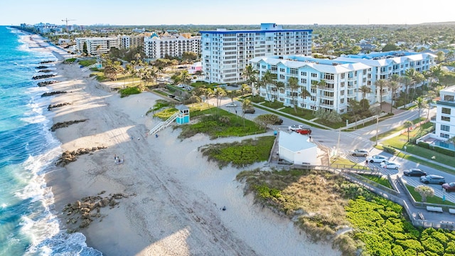 drone / aerial view featuring a view of the beach, a water view, and a view of city