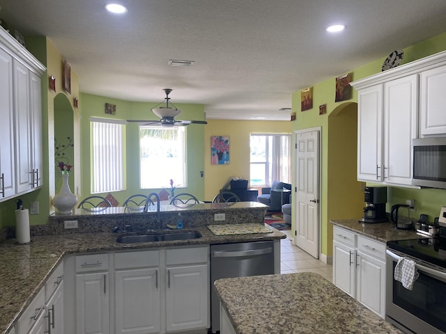 kitchen featuring white cabinetry, a peninsula, appliances with stainless steel finishes, and a sink