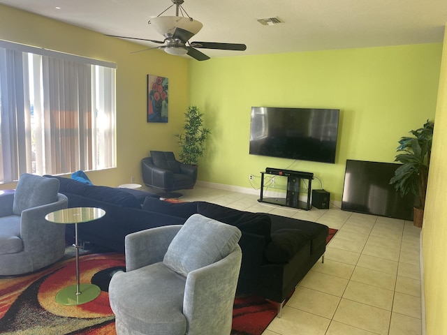 tiled living room featuring baseboards, visible vents, and ceiling fan