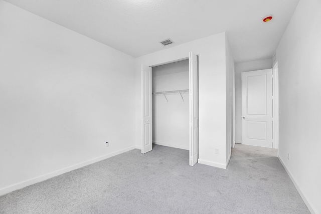 unfurnished bedroom with carpet, a closet, visible vents, and baseboards