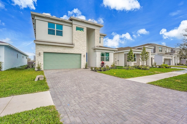 view of front of home featuring a garage, stone siding, a front lawn, and decorative driveway