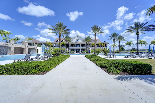 view of home's community with a pool and a patio