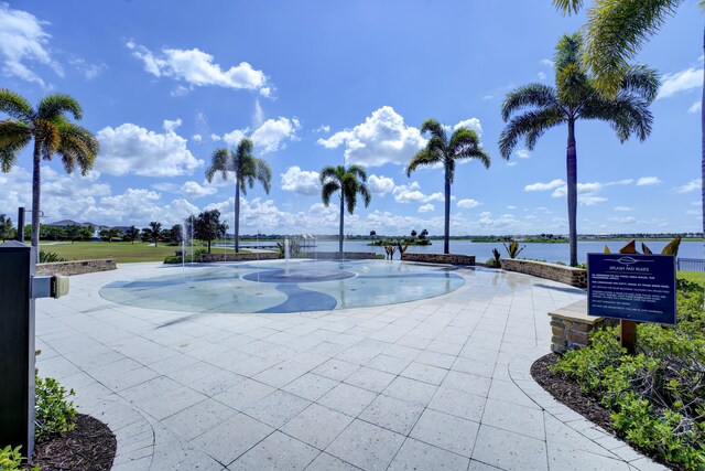 surrounding community with a water view and a yard