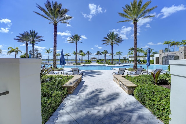 view of property's community with a swimming pool and a patio