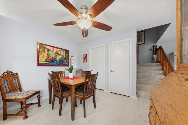 dining room featuring stairs, ceiling fan, light tile patterned floors, and baseboards