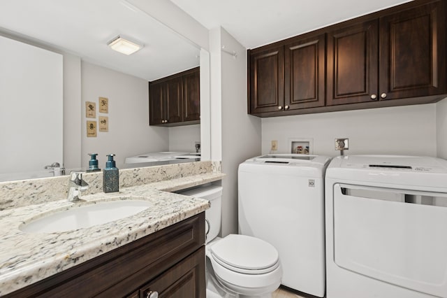 bathroom featuring toilet, vanity, and washing machine and clothes dryer