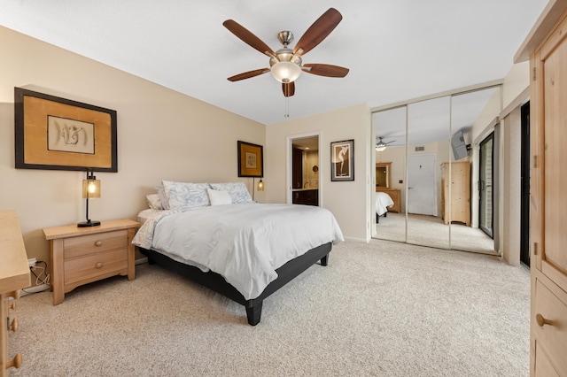 bedroom featuring light carpet, ceiling fan, baseboards, and ensuite bathroom