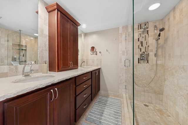 bathroom featuring double vanity, a stall shower, and a sink