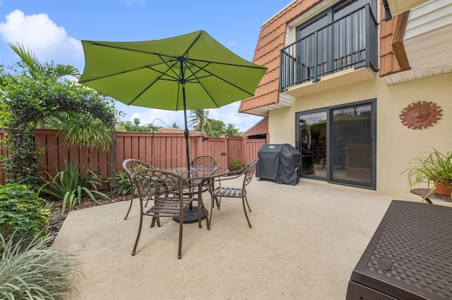 view of patio / terrace with outdoor dining space, grilling area, fence, and a balcony