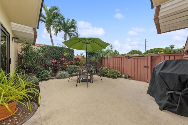 view of patio featuring outdoor dining space, fence, and area for grilling