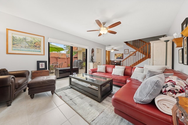 living area featuring ceiling fan, stairway, and light tile patterned floors