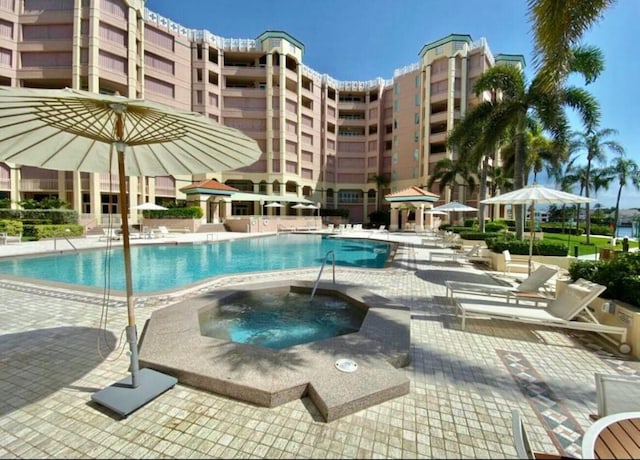 community pool featuring a community hot tub and a patio area