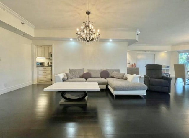 living room featuring ornamental molding, a chandelier, dark wood-type flooring, and baseboards