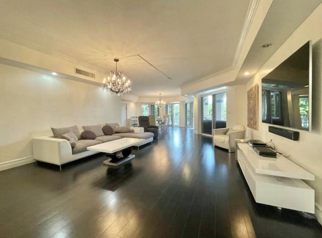 living area with visible vents, a chandelier, dark wood finished floors, and ornamental molding