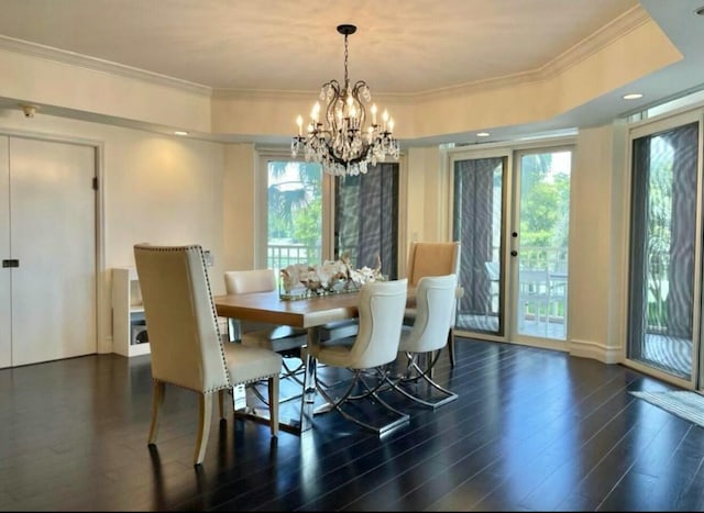 dining area with a chandelier, a wealth of natural light, crown molding, and wood finished floors
