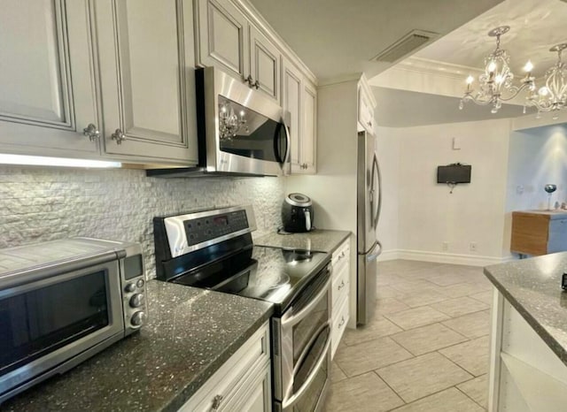 kitchen with visible vents, appliances with stainless steel finishes, decorative backsplash, dark stone counters, and crown molding