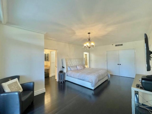 bedroom featuring wood finished floors, visible vents, and a notable chandelier