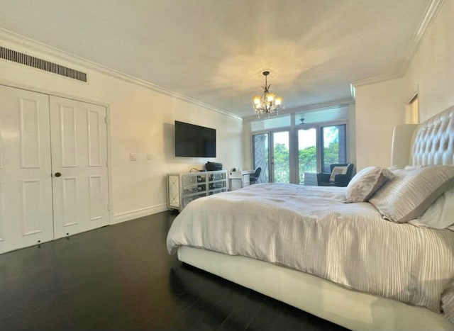 bedroom featuring visible vents, an inviting chandelier, ornamental molding, wood finished floors, and baseboards