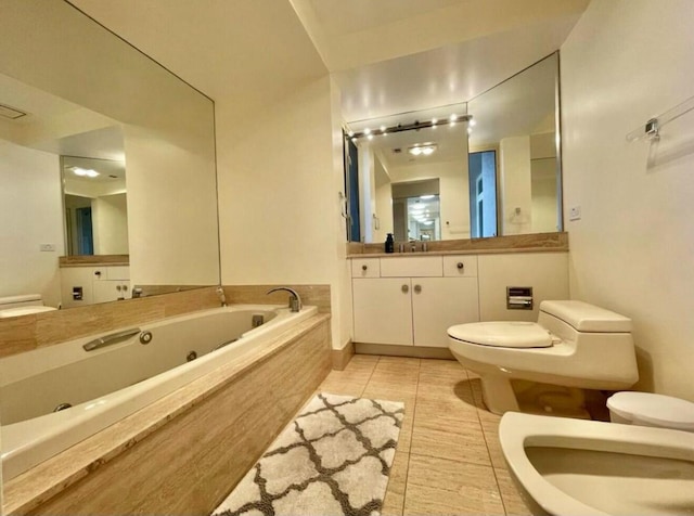 full bathroom featuring toilet, a bidet, vanity, a whirlpool tub, and tile patterned floors