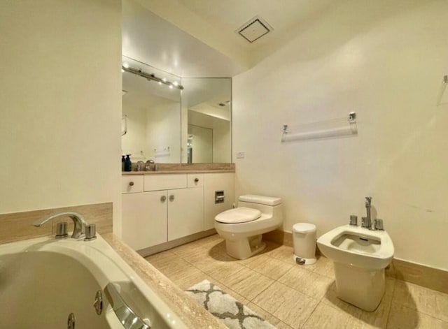 full bath featuring a garden tub, toilet, a bidet, vanity, and tile patterned floors