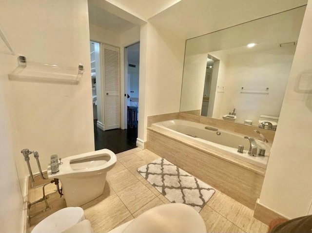 bathroom with tile patterned flooring, a bidet, toilet, and a bath