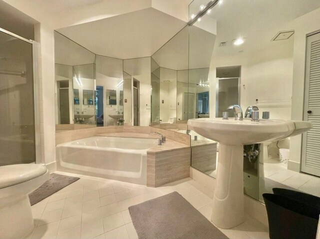 bathroom with toilet, a stall shower, tile patterned flooring, and a bath