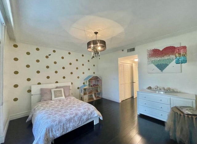 bedroom with baseboards, visible vents, dark wood-style floors, ornamental molding, and a chandelier