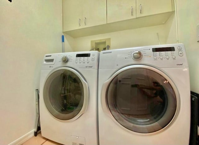 clothes washing area with cabinet space, baseboards, separate washer and dryer, and light tile patterned flooring