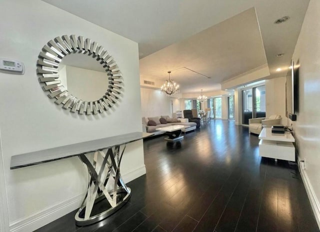 interior space featuring a chandelier, dark wood-style flooring, visible vents, and baseboards