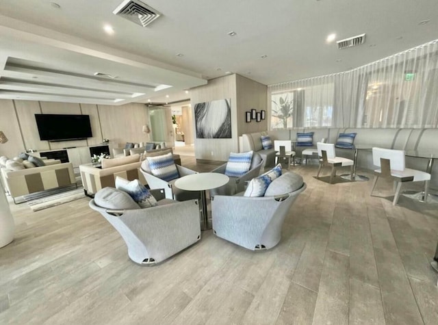 living area featuring visible vents and wood finished floors