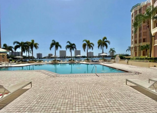 community pool with a view of city and a patio